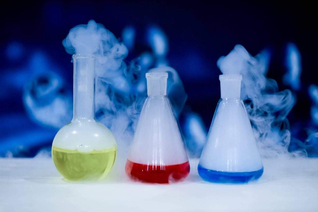 Δοχεία εργαστηρίου με χρωματισμένα υγρά, που βγάζουν σύννεφα